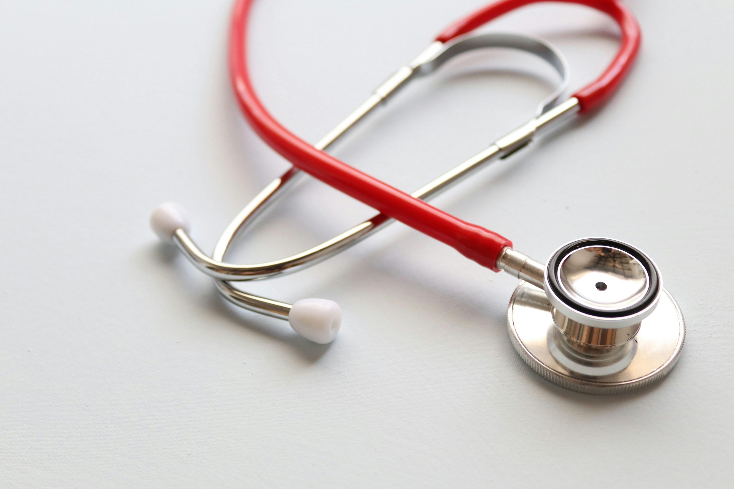 Close-up of a red stethoscope symbolizing medical care and healthcare diagnostics.